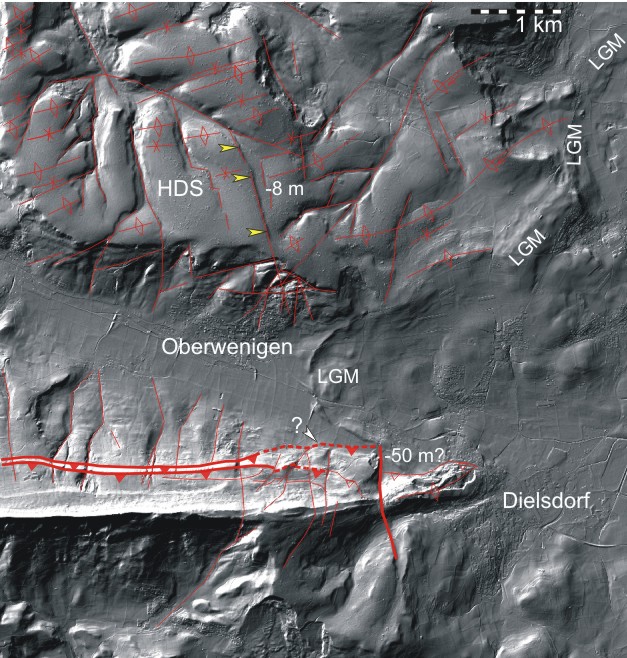 Figur 108-5: LiDAR-Reliefaufnahme im Gebiet von Oberweningen und Dielsdorf. Im unteren Teil ist das östliche Ende der Lägern gut erkennbar. Nördlich davon befindet sich das Wehntal mit dem letzteiszeitlichen (LGM) Moränenwall bei Schöfflisdorf. Im oberen Bildteil sind die Höheren Deckenschotter Vorkommen (HDS) der Egg sichtbar. In diesem Gebiet ist anhand des Schattenwurfs eine auffällige Linie (gelbe Pfeile) zu erkennen. Bei 15° Lichteinfallwinkel aus NW ergibt sich daran eine Sprunghöhe von ca. 8 m. mit einer Absenkung auf der Ostscholle bzw. Kippung eines 20° streichenden Blocks nach Westen. In rot sind mit durchgezogene Linien offensichtliche und wahrscheinliche Störungen und mit gestrichelten Linien vermutetet Störungen markiert. Die Abbildung wurde ohne Veränderungen aus ENSI 33/44 übernommen.